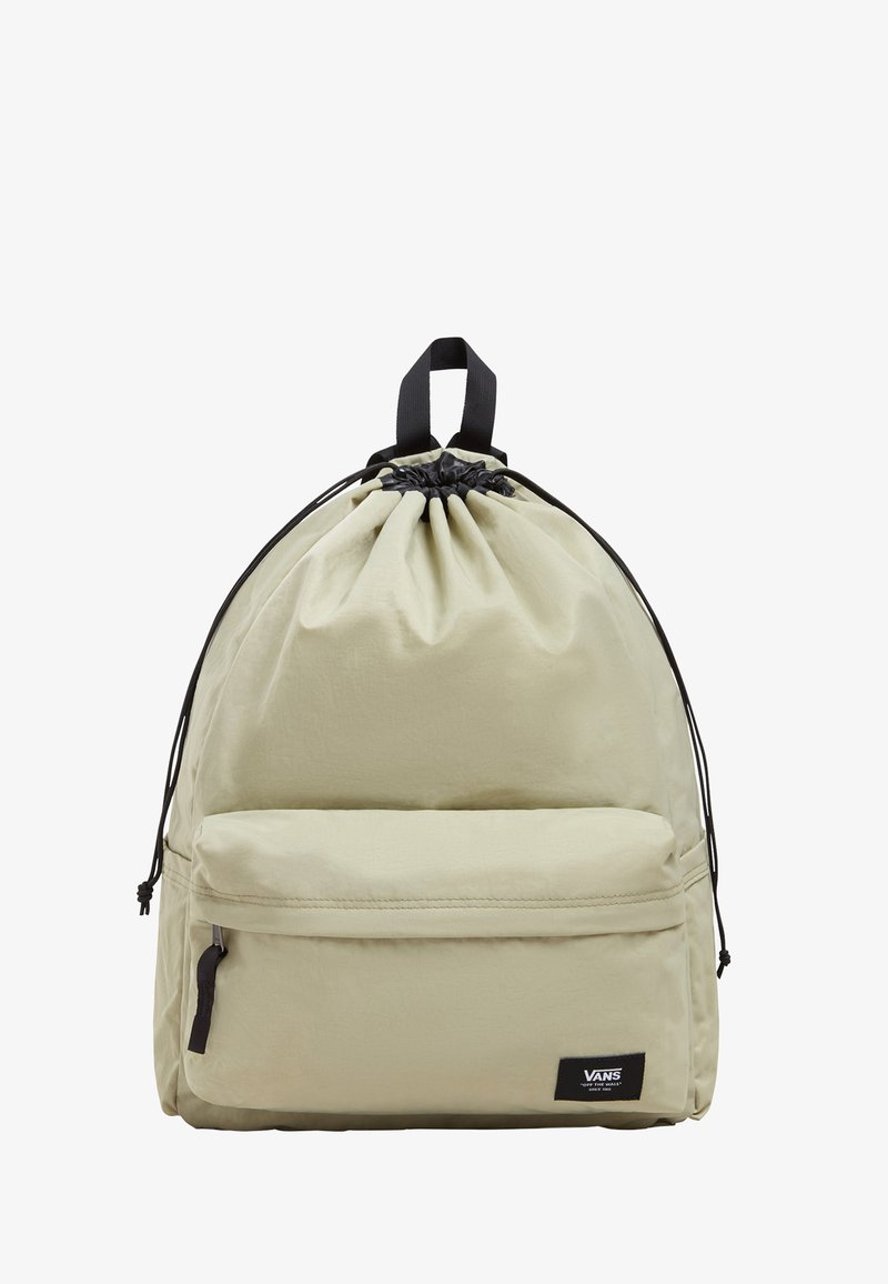 Mochila de tiro en color caqui con forma redondeada, que cuenta con un bolsillo frontal con cremallera, acentos negros y un parche de la marca. Textura de tela lisa.