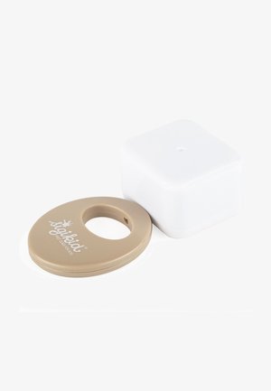 Beige circular Soiled brand teething ring with wide hole beside small white square container on white background.
