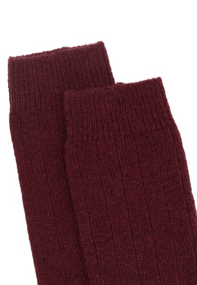 Burgundowe skarpetki plecione z grubymi mankietami, wykonane z fakturowanego, ciepłego materiału idealnego dla komfortu i izolacji.