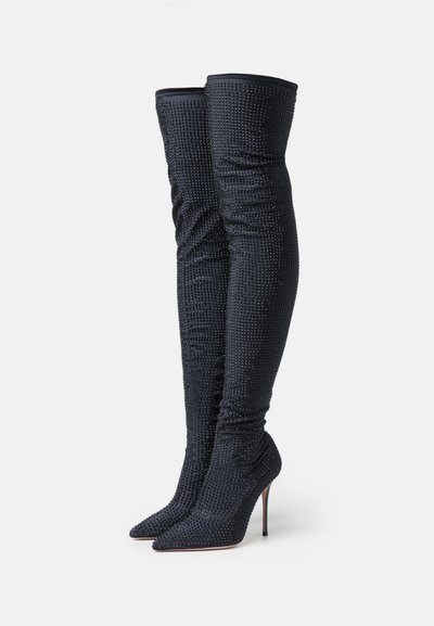 Knee-high, black, rhinestone-embellished stiletto boots with a pointed toe and ruched texture, featuring a snug fit through the shaft.