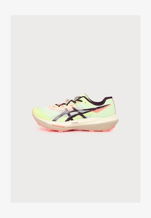 Chaussure de course vert clair avec des accents noirs et roses, semelle épaisse beige, logo noir sur le côté et détails noirs et roses sur un fond uni.