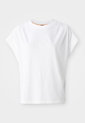 T-shirt blanc à manches courtes avec une coupe décontractée. Il présente un col rond et un détail de logo discret à l'avant. Fabriqué en tissu 100% coton.