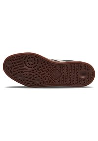 Semelle de chaussure noire texturée avec une base en caoutchouc marron. Présente des motifs circulaires et en zigzag. Logo situé près de la section centrale.