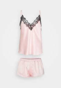 Ensemble de nuit en satin rose comprenant un débardeur orné de dentelle noire et un short assorti avec taille élastique. Texture lisse, design minimaliste.