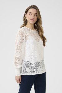 White lace blouse featuring floral patterns, long sleeves with gathered cuffs, and a gradient design fading to darker shades at the hem.