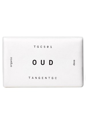 Saponetta rettangolare bianca con etichetta "OUD" e testi neri che riportano "TGC501", "organic", "soap" e "TANGENTGC".