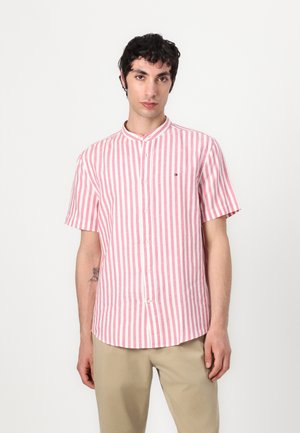 Camisa de manga corta con cuello en rayas verticales rosas y blancas; cuenta con un cierre de botones y un pequeño logo en el pecho. Hecha de tejido ligero.