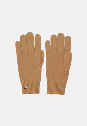 Paire de gants tricotés couleur chameau avec poignets côtelés et un petit logo rectangulaire rouge, blanc et bleu sur le poignet du gant gauche.