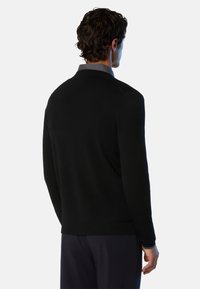 Pull noir avec une texture lisse et un col haut. Présente un design ajusté, des manches longues et une silhouette épurée et minimaliste.