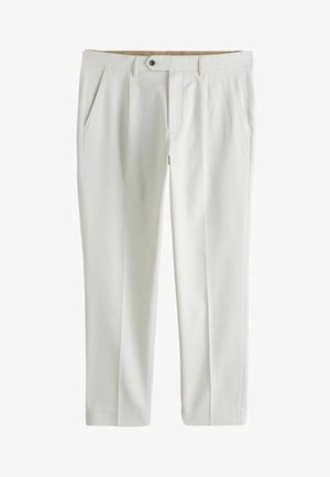 Fehér, szabott nadrág elülső zsebekkel, övbújtatóval és egy gombos zárral a derékrésznél, egyszínű háttér előtt bemutatva.