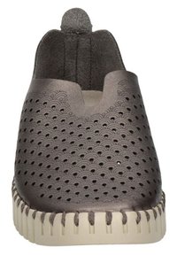 Zapatos gris de tipo slip-on con parte superior perforada que presenta patrones en forma de ola, forro de tela suave y una suela de goma en color crema que contrasta.