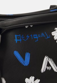 Schwarze Tasche mit lebhaften blauen und weißen abstrakten Mustern. Die Textur ist glattes Leder mit einem strukturierten Design und geprägtem LOGO-Detail.