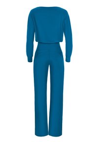 Tuta teal con maniche lunghe, scollatura ampia e vita aderente con pantaloni a gamba larga. Tessuto liscio e morbido con cuciture minime.