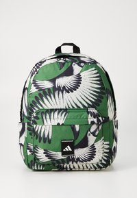 Green backpack featuring a black and white bird print. Made of durable fabric with a front pocket and black brand logo patch.