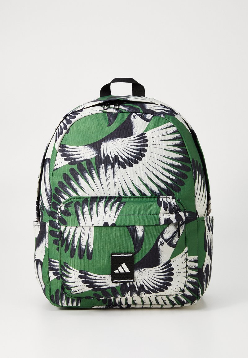 Green backpack featuring a black and white bird print. Made of durable fabric with a front pocket and black brand logo patch.