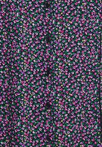 Tessuto a camicia floreale con uno sfondo scuro e piccoli gruppi di fiori rosa, viola e gialli, arricchiti da foglie verdi.