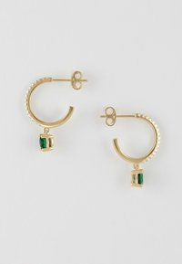 Boucles d'oreilles en or en forme de créoles avec des bords texturés, chacune arborant un petit pendentif rectangulaire en pierre précieuse verte.