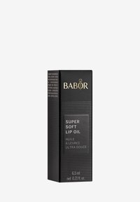 Caja rectangular negra para Super Soft Lip Oil. Presenta texto dorado y textura acanalada. Tamaño: 6.5 ml. Contiene etiquetas en varios idiomas.
