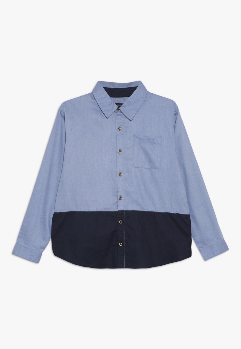 Chemise boutonnée bleu et marine à manches longues, avec col, poche poitrine simple, et panneau inférieur contrastant. Texture lisse, design classique.