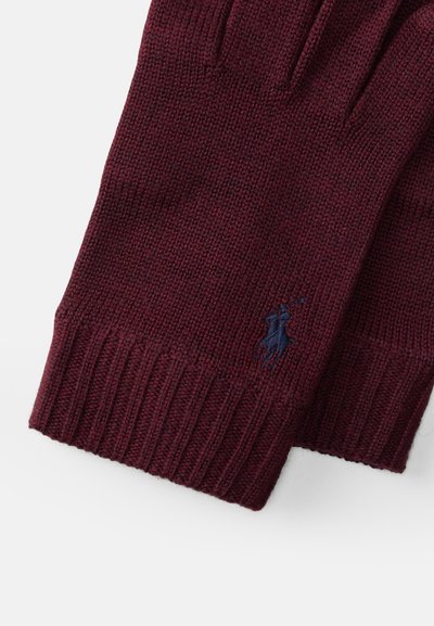 Pletene burgundske rokavice z rebrastimi manšetami, ki na predelu zapestja nosijo manjši mornarsko modri logotip konja z jezdecem. Mehka tekstura.