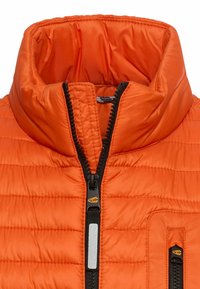 Helles orangefarbenes gesteppte Jackett mit aufstehendem, gepolstertem Kragen und zwei schwarzen Reißverschlussverschlüssen, einer mit reflektierendem Streifen.