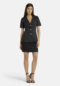 Zwarte linnen blazerjurk met korte mouwen, een reverskraag, vier grote knoopsluitingen, gecombineerd met een aansluitende zwarte miniskirt.