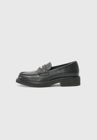 Black leather loafers featuring a woven accent on the vamp, a gold logo detail, and a chunky black rubber sole. Smooth texture with slight gloss.