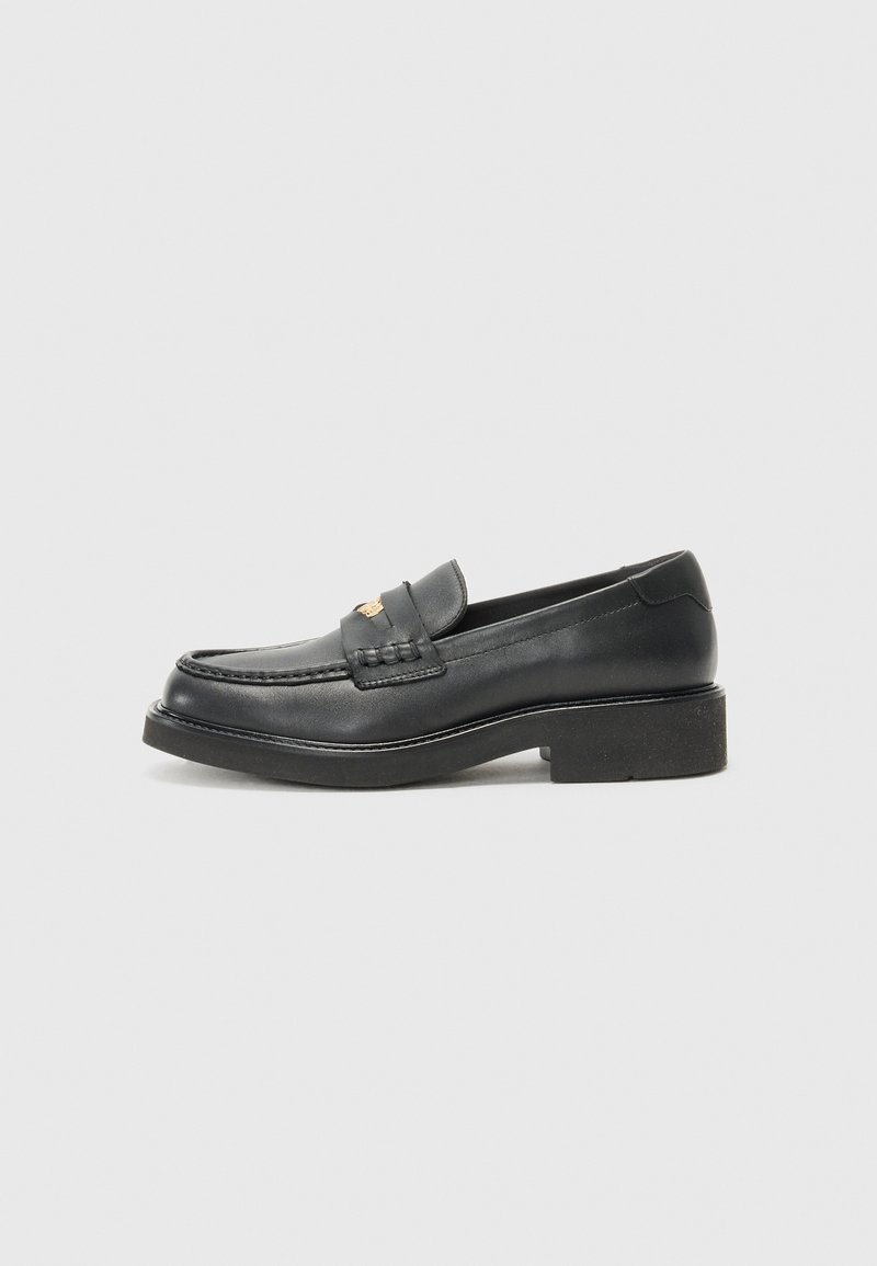 Black leather loafers featuring a woven accent on the vamp, a gold logo detail, and a chunky black rubber sole. Smooth texture with slight gloss.