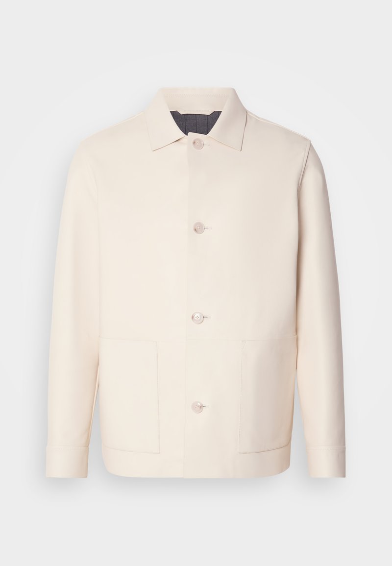 Lichtbeige jacket van glad stof, met een puntige kraag, knopen aan de voorkant en twee grote opgestikte zakken.