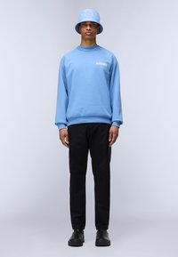 Felpa azzurra, pantaloni cargo neri e cappello a secchiello abbinato. Tessuto morbido, vestibilità comoda, con dettaglio del logo sulla maglietta e sul cappello.