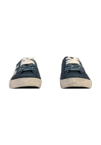Sneakers in tela blu con lacci bianchi, suole in gomma strutturata e un aspetto leggermente usurato; design con punta arrotondata e branding minimal.