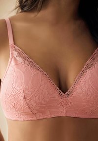 Bralet din dantelă roz cu un design triunghiular, margini ondulate și modele florale. Bretelele ajustabile îmbunătățesc potrivirea și susținerea.