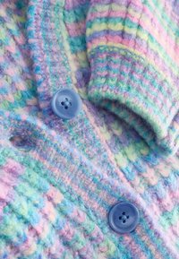Tissu tricoté doux avec des rayures pastel en rose, bleu, vert et violet, agrémenté de deux grands boutons bleus.