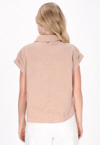 Kurzärmelige, hellrosa Bluse mit strukturierten floralen Stickereien, einem Kragen und aufgerollten Ärmelabschlüssen, mit geradem Saum und weichem Stoff.