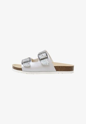 Witte slipper met twee glinsterende zilveren gespen, kurken voetbed en een witte buitenzool. Vuilafstotend bovenmateriaal met een eenvoudig ontwerp.