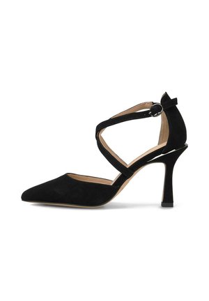 Zapato de tacón de ante negro con punta afilada, delgada correa al tobillo y tacón de aguja. Presenta una textura suave y un acento de hebilla circular.