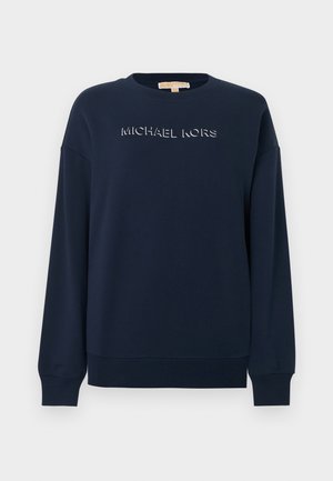 Tumesinine pehme kangaga kampsun, millel on ümar kaelus, langetatud õlad ja esiküljel reljeefne logo. Soonilised mansetid ja alumine äär.