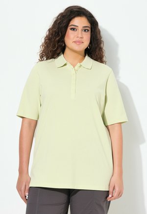 Camisa polo amarilla clara de manga corta, con cuello y una tapeta de botones. Textura suave, corte relajado, adecuada para uso informal.