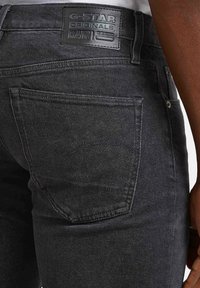 Los vaqueros de mezclilla negros presentan un acabado texturizado, un diseño de bolsillo trasero y un parche de cuero G-Star Originals en la cintura.