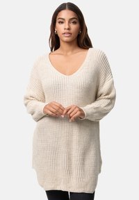 Suéter de punto beige claro con un escote en V profundo, mangas holgadas y un patrón texturizado. Corte casual, que llega hasta la mitad del muslo con aberturas laterales.