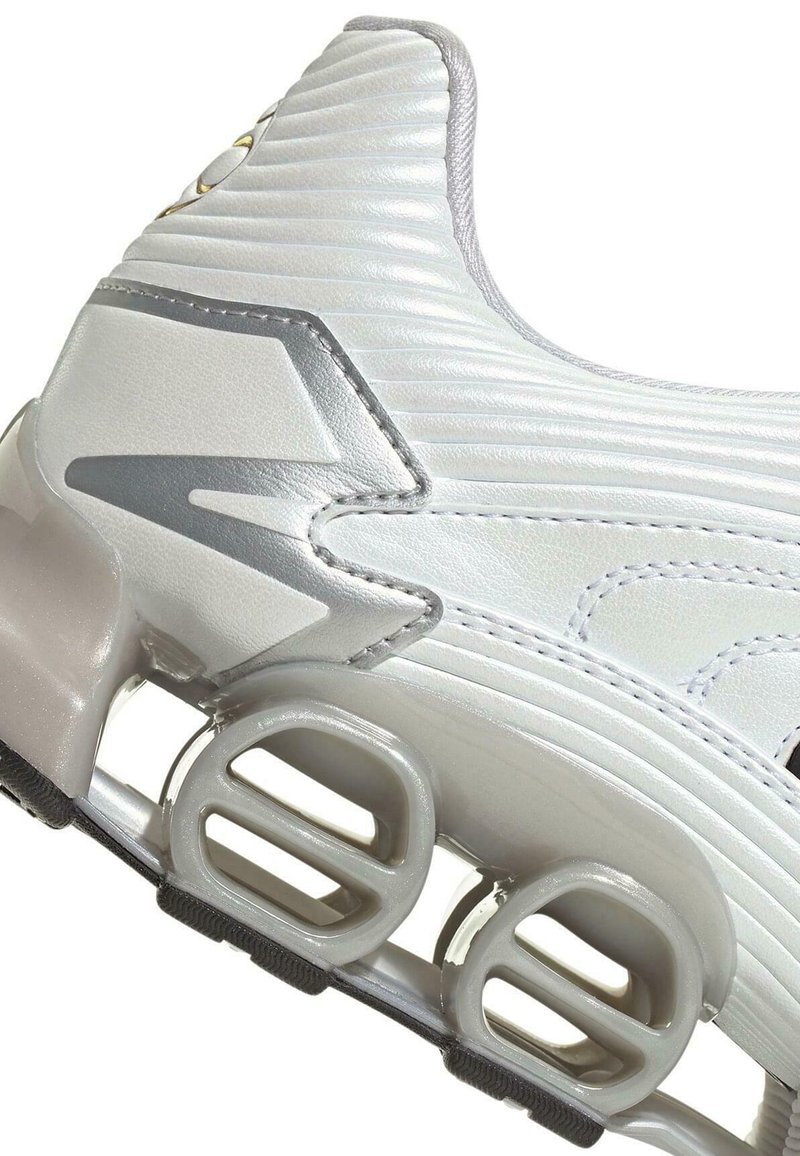 Weißer Sportschuhabsatz mit silbernen Akzenten und einzigartigen, runden, hohlen Dämpfungseinheiten in der Sohle zur Stoßabsorption.