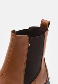 Stivale alla caviglia in pelle marrone con pannelli laterali elasticizzati, dotato di interni in tessuto e una linguetta sul retro per una facile calzata.