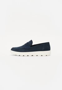 Mocassins pour hommes en suède bleu marine, dotés d'un profil bas, d'un upper doux et d'une semelle en caoutchouc blanc avec un motif de traction pour l'adhérence.