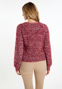 Rode donzige trui met een gestructureerd breisel, ronde halslijn en lange mouwen. Gekort ontwerp met een relaxed fit.