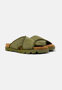Infradito verde oliva con cinturini incrociati in tessuto, una soletta in suede e una suola in gomma testurizzata con ritagli arrotondati.