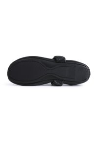 Zapato de cuero negro con una suela de goma flexible. Cuenta con una correa acolchada para mayor comodidad y un detallado texturizado en la sección superior.