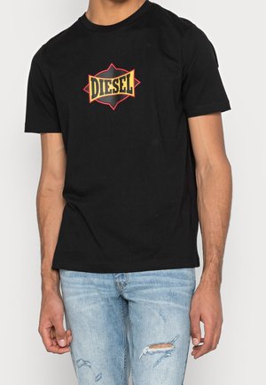 T-shirt nera in cotone con un audace logo "DIESEL" giallo e rosso a forma di diamante sul davanti. Maniche corte, vestibilità comoda.