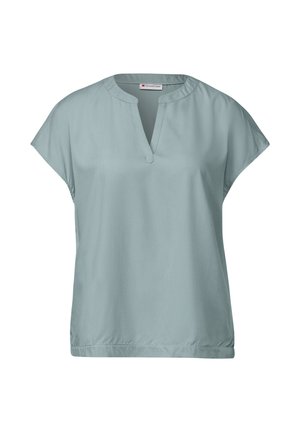 Blouse vert menthe en tissu lisse, avec un décolleté en V, des manches courtes et une coupe ample, dotée d'un ourlet légèrement froncé.