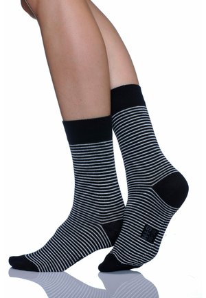 Schwarz-weiße gestreifte Socken mit einem gerippten Bündchen, die eine glatte Textur und eine verstärkte Zehenpartie aufweisen. Das Design zieht sich durchgehend durch.
