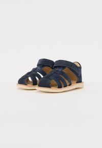 Sandalias de ante azul marino con diseño troquelado, dos correas de Velcro para un ajuste seguro y suela de goma de color claro con bordes texturizados.
